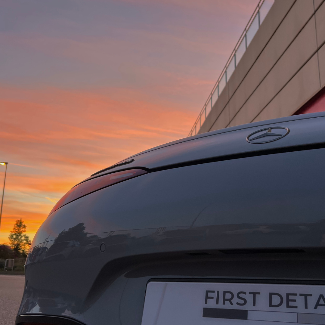 Detalle de la parte trasera de un Mercedes al atardecer con la placa de First Detail