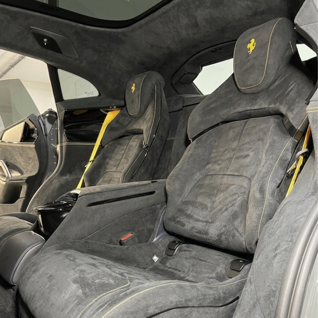 Asientos de alcántara gris con detalles amarillos en el interior de un Ferrari